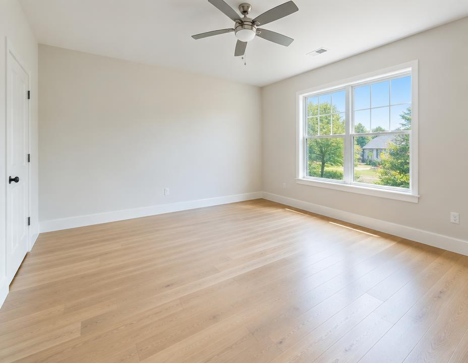 Empty freshly cleaned bedroom with light wood floors